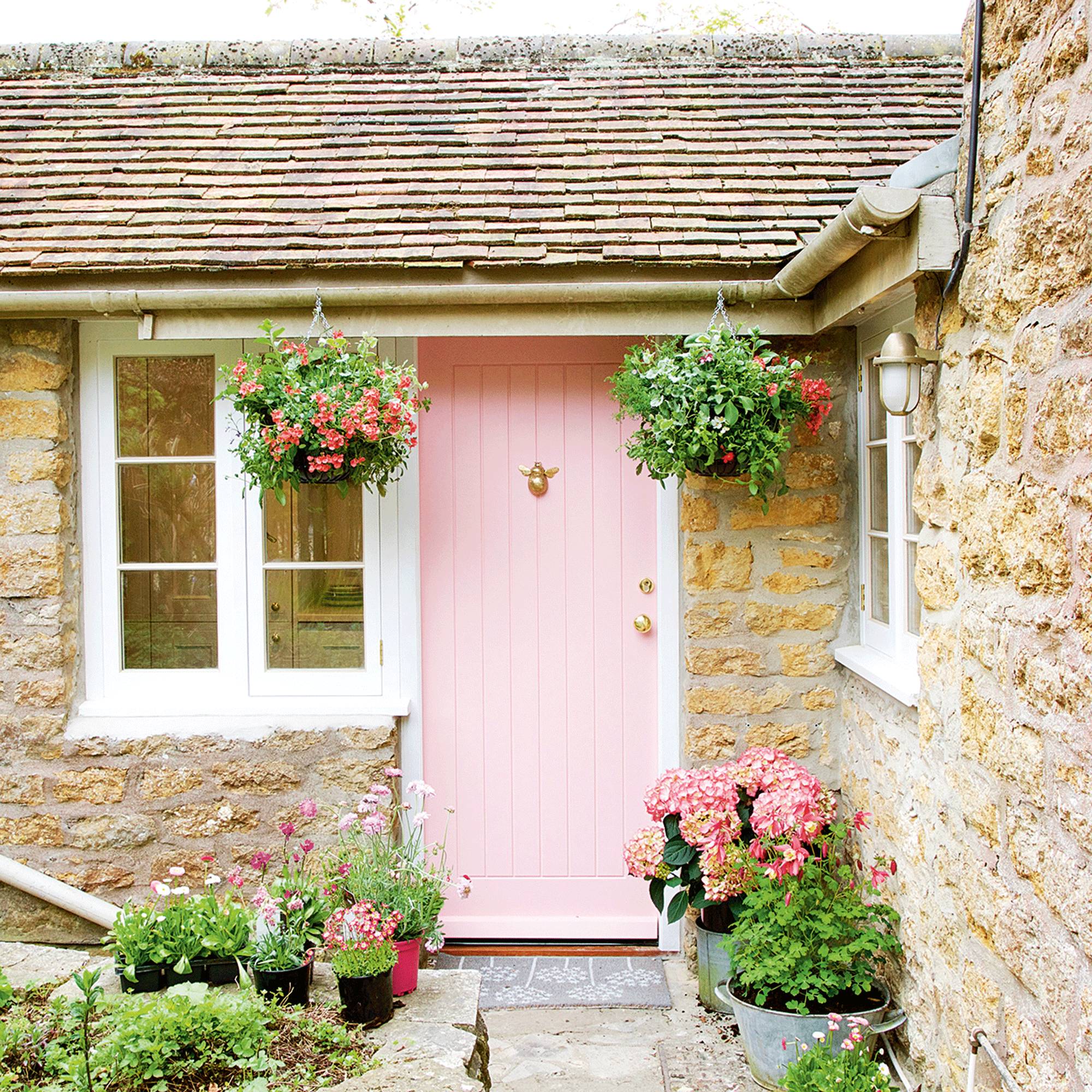 Pink front door with potted plants on each side featured in outdoor decorating ideas