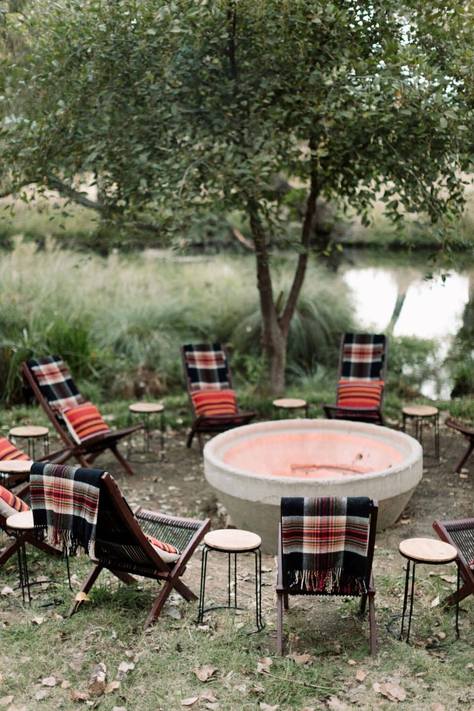 Outdoor decorating ideas featuring firepit with chairs and layered blankets around it
