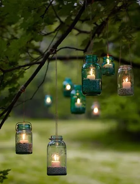Colored lanterns with candles inside hanging against in the outdoor ideas decorating