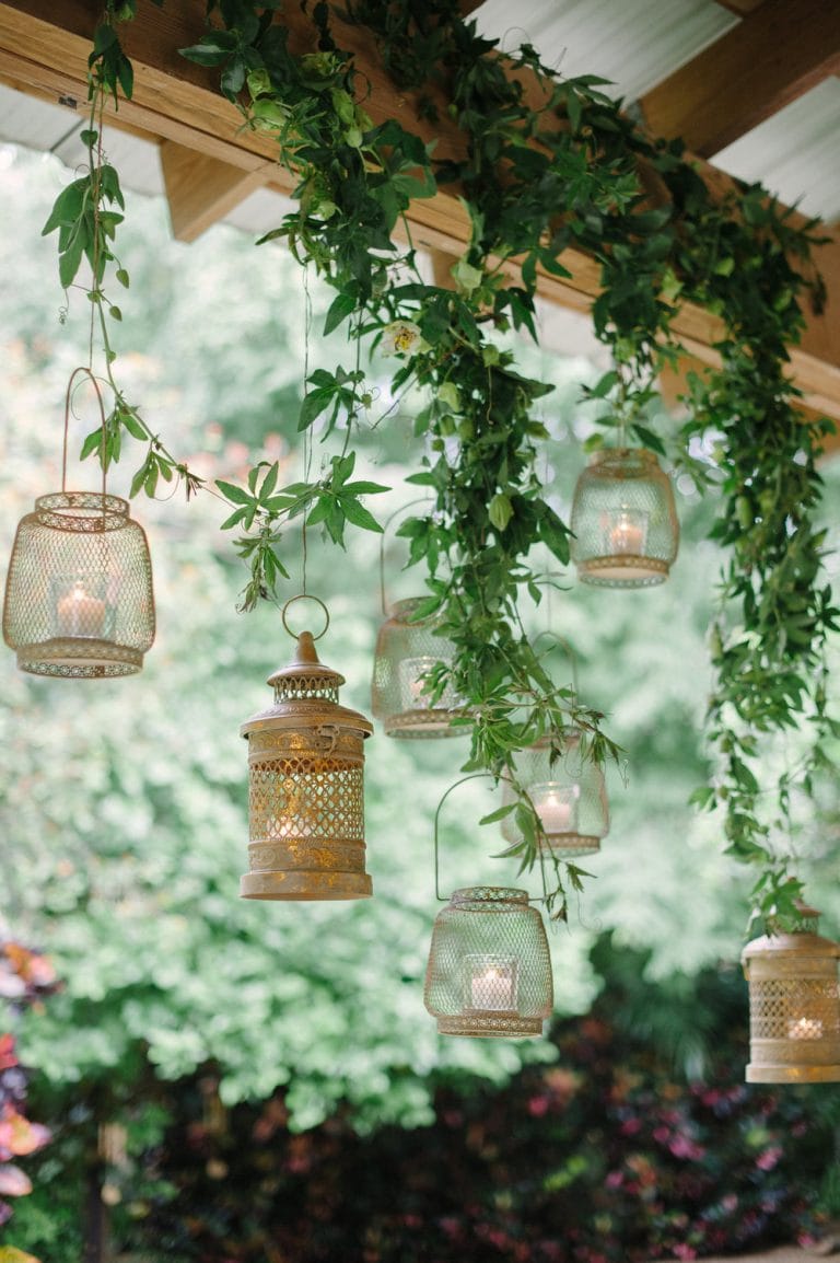 outdoor decorating ideas featuring hanging lanterns against hanging plants