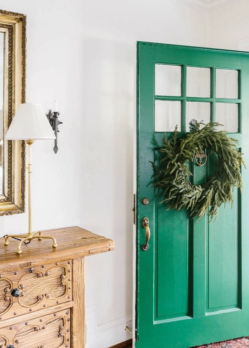 Green front door with greenery wreath featured in outdoor decorating ideas