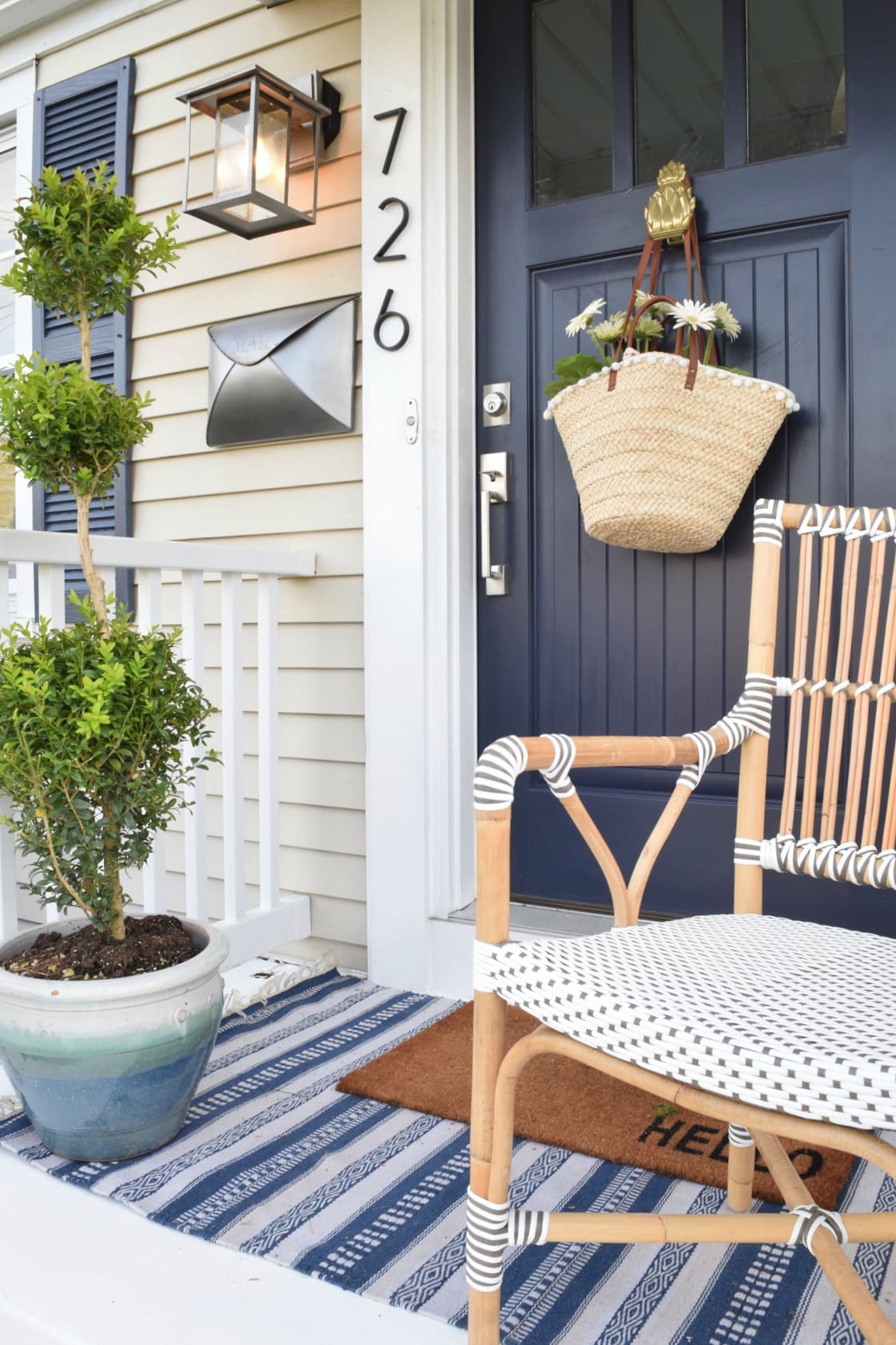 Navy front door with floral basket featuring outdoor decorating ideas