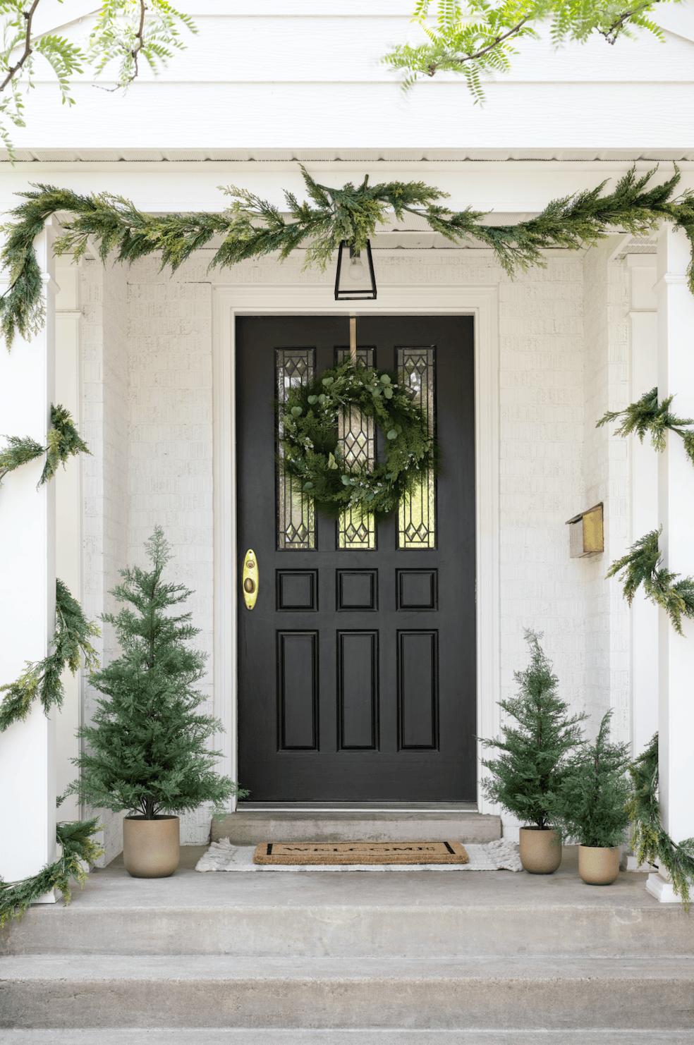 Outdoor decorating ideas featuring front door with traditional garland style