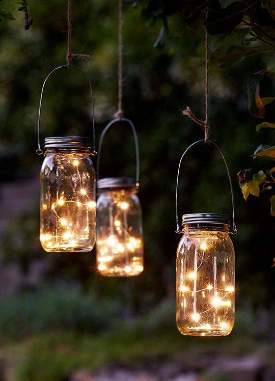 Lanterns with string lights inside hanging against in the outdoor ideas decorating