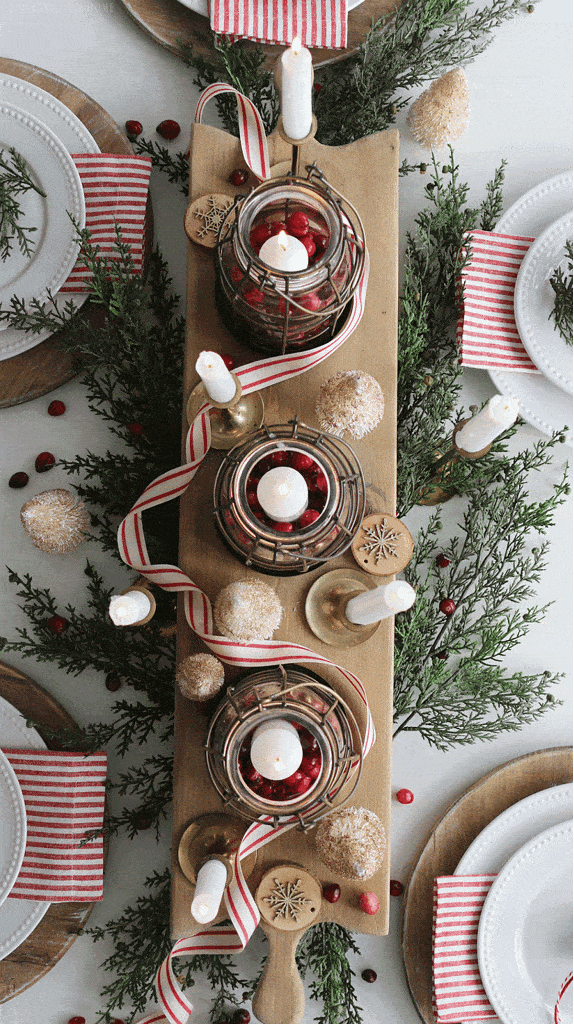 Traditional elegant centerpiece idea featuring greenery and candles with red berries