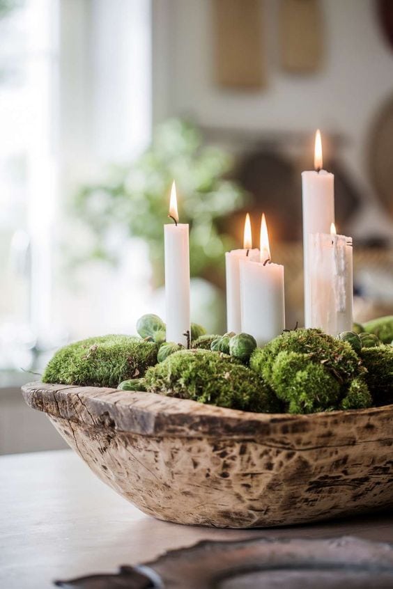 Traditional elegant centerpiece idea featuring candles in a bowl filled with greenery
