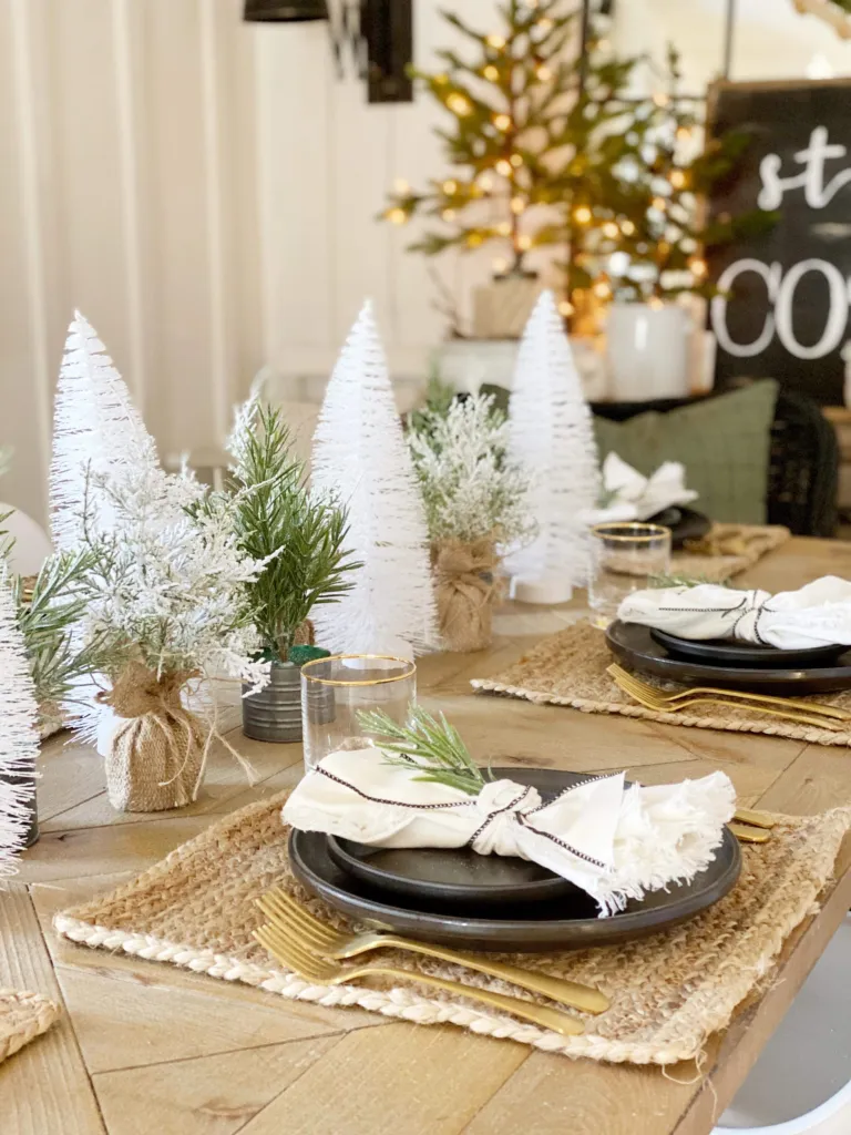 Mini brush trees in white next to potted plants for a centerpiece idea