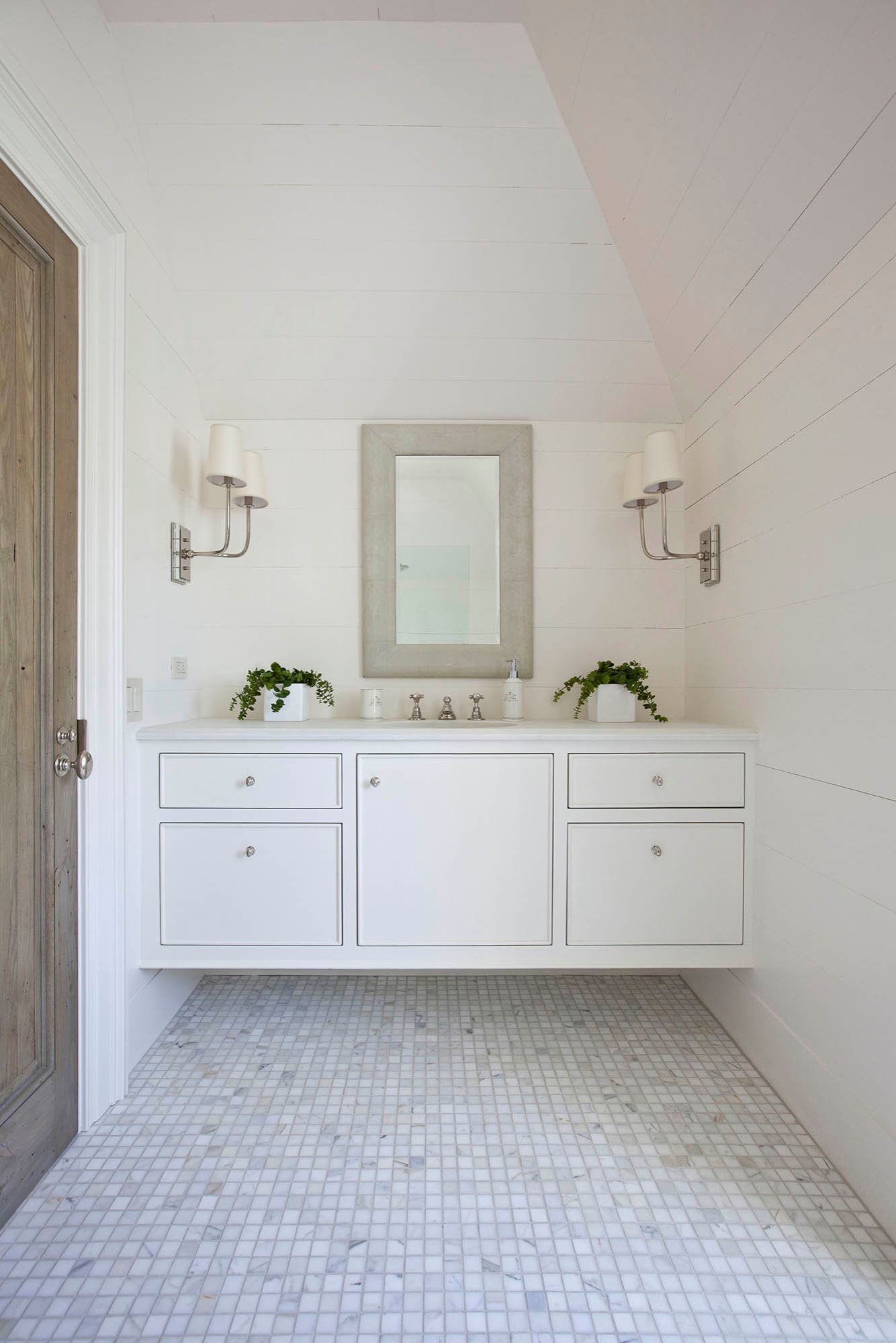 Bathroom in modern home tour featuring Carrara marble basket weave flooring