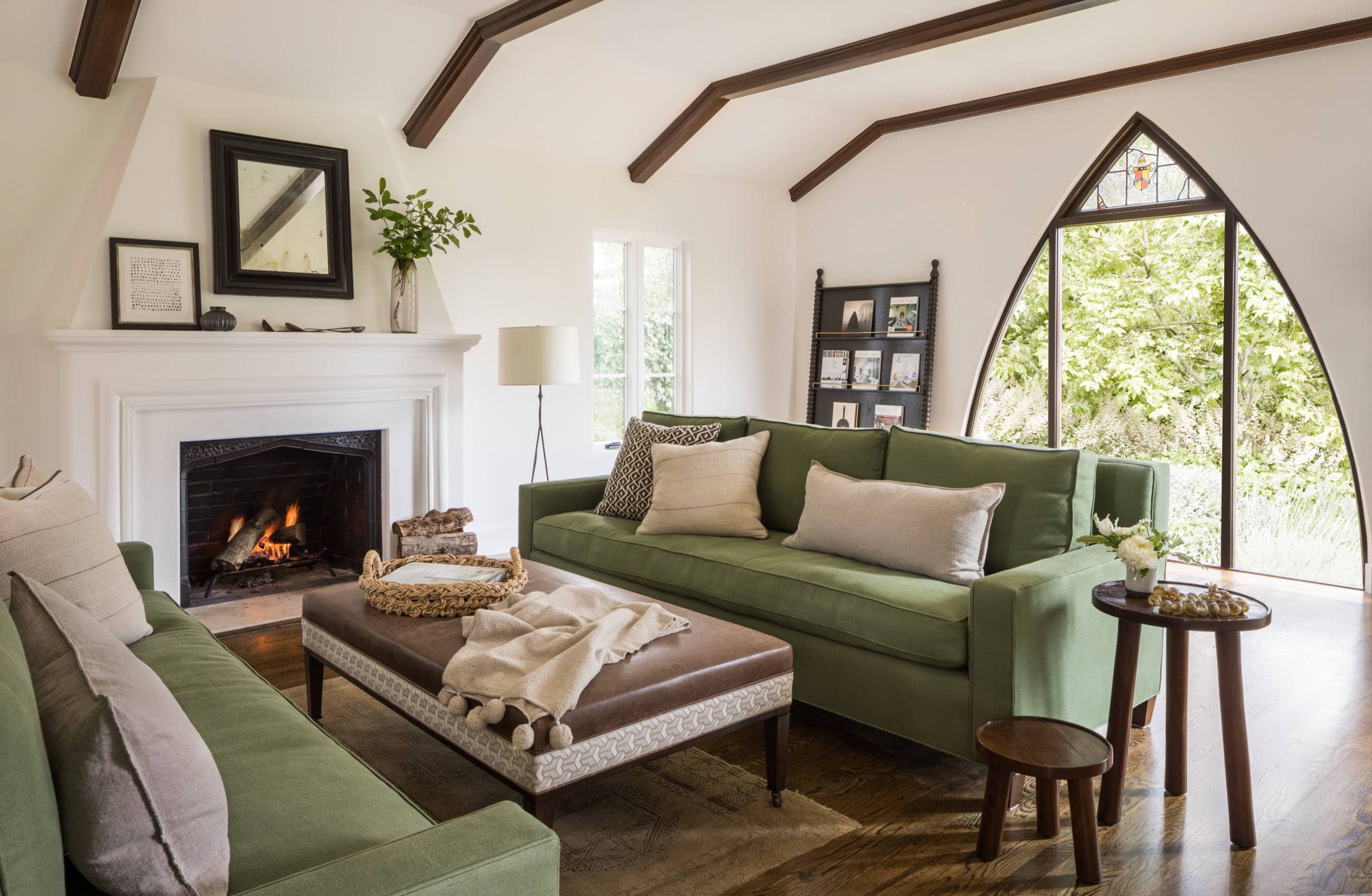 California Casual Design home tour in Hillsborough featuring a Spanish colonial style living room with pointy arched windows and green sofas