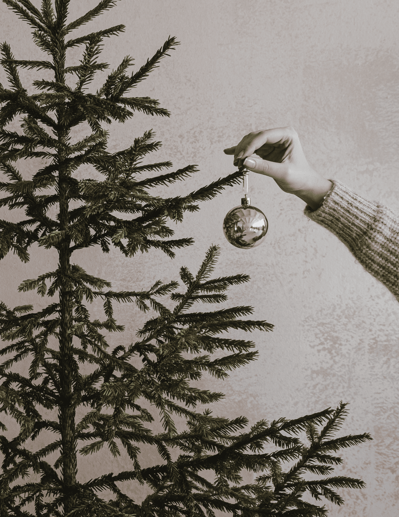 hand removing christmas ornament from tree