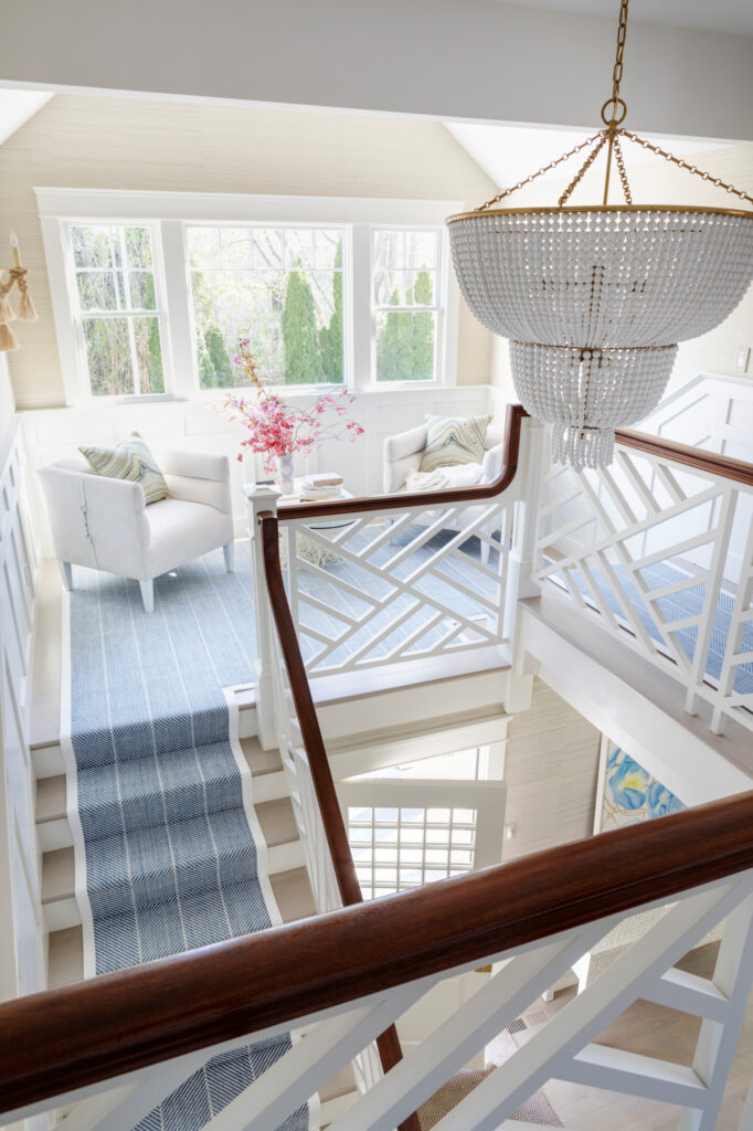 Staircase with blue carpet from Matunuck Beach residence featured in Home Tour