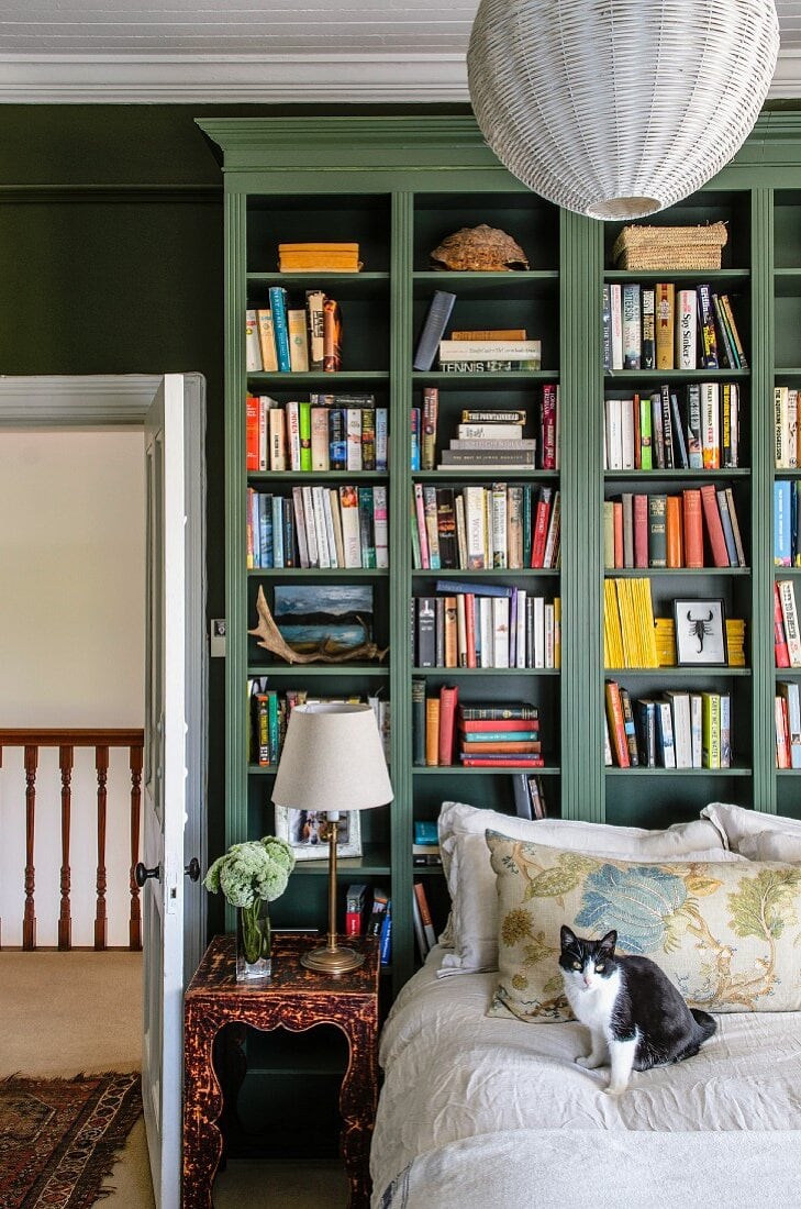 Traditional library in dark green as example of green home decor
