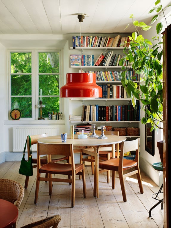 Eclectic style decor idea featuring modern dining room with round white table and red modern pendant light