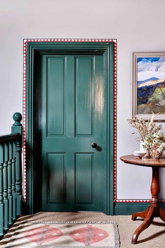 Elegant room featuring architectural details like wallpaper trims around green door