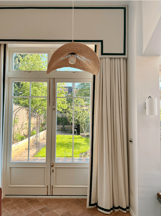 Window featuring architectural details like window cornice and matching curtains