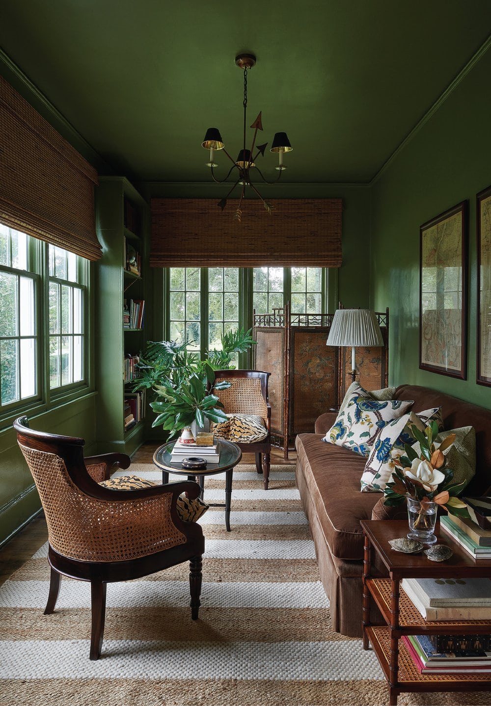 Green livingroom featured with tropical accents in interiors designed by Heather Chadduck