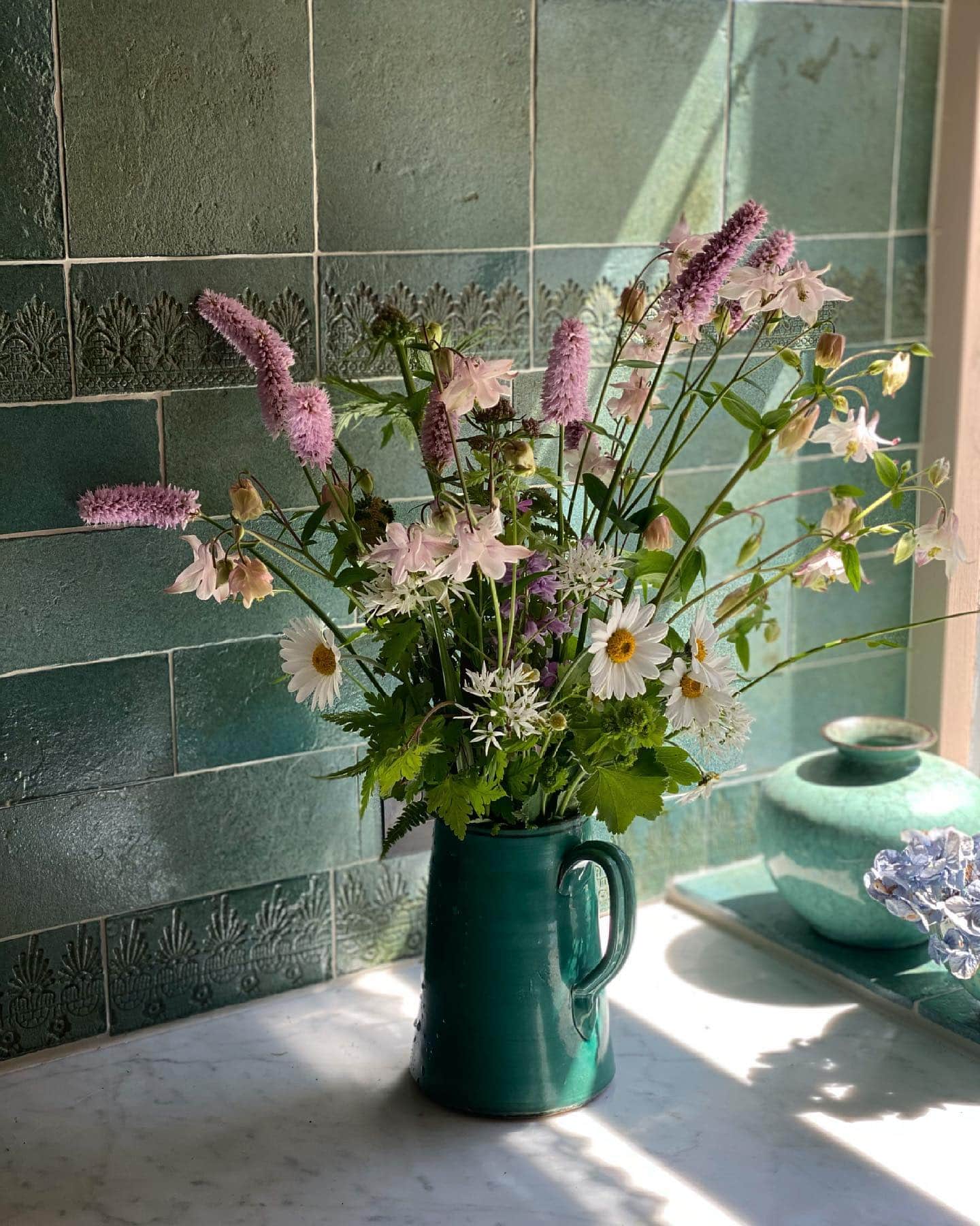 green vase with floral arrangement in green kitchen featured in summer decor tips