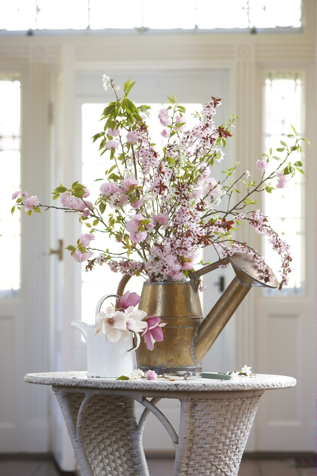 vintage watering can in entryway with flowers featured in summer decor tips