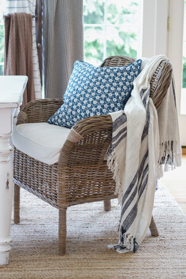 summer decor tips featuring wicker chairs with linen throw blannket