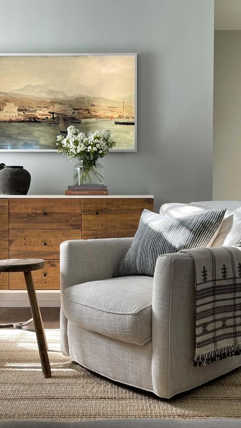 Decorating with neutrals example featuring reading nook with armchair and round tall side table