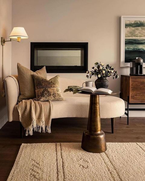 Decorating with neutrals example featuring warm cozy nook with small sofa and bronze round tall side table