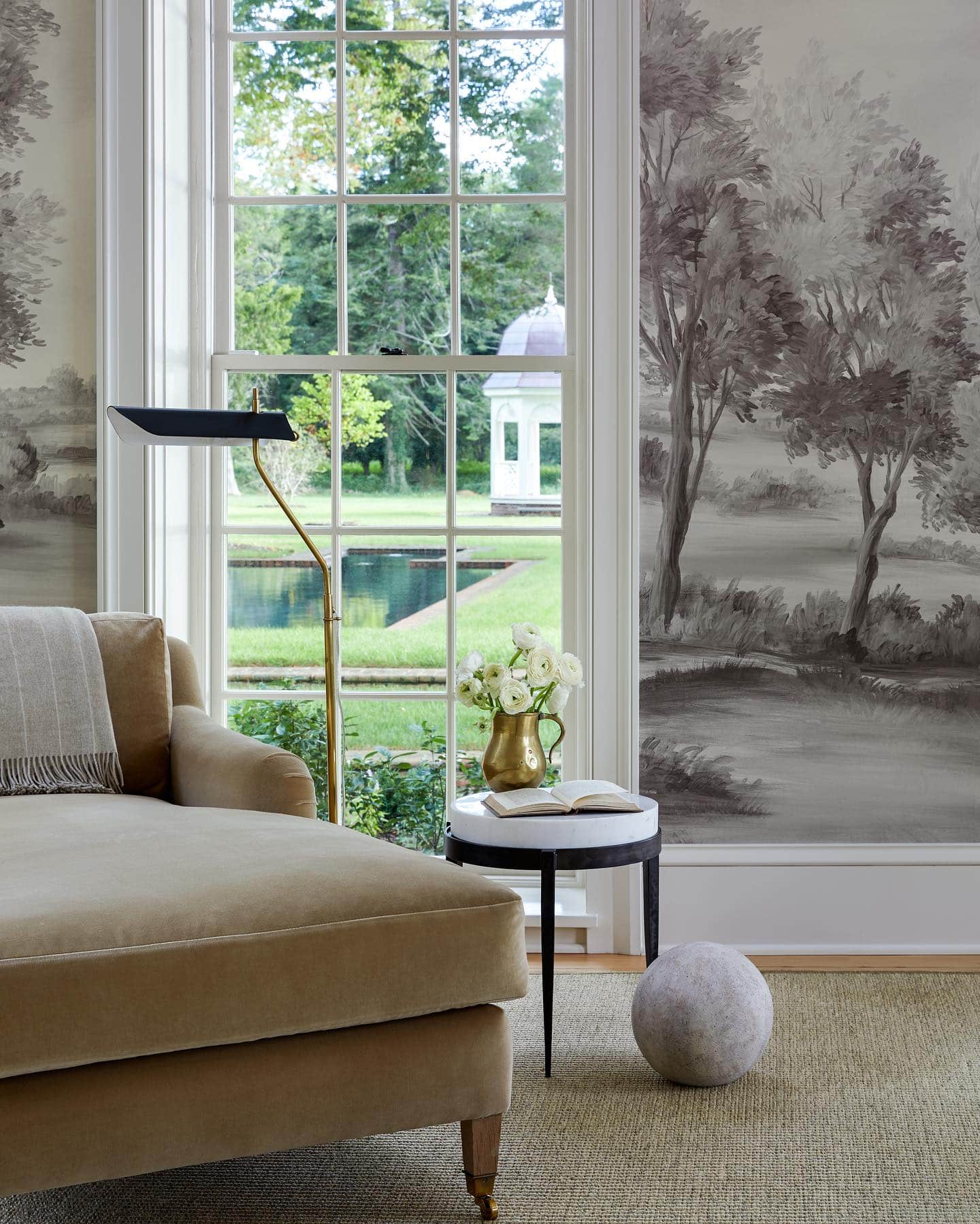 Decorating with neutrals example featuring reading nook with armchair and round tall side table