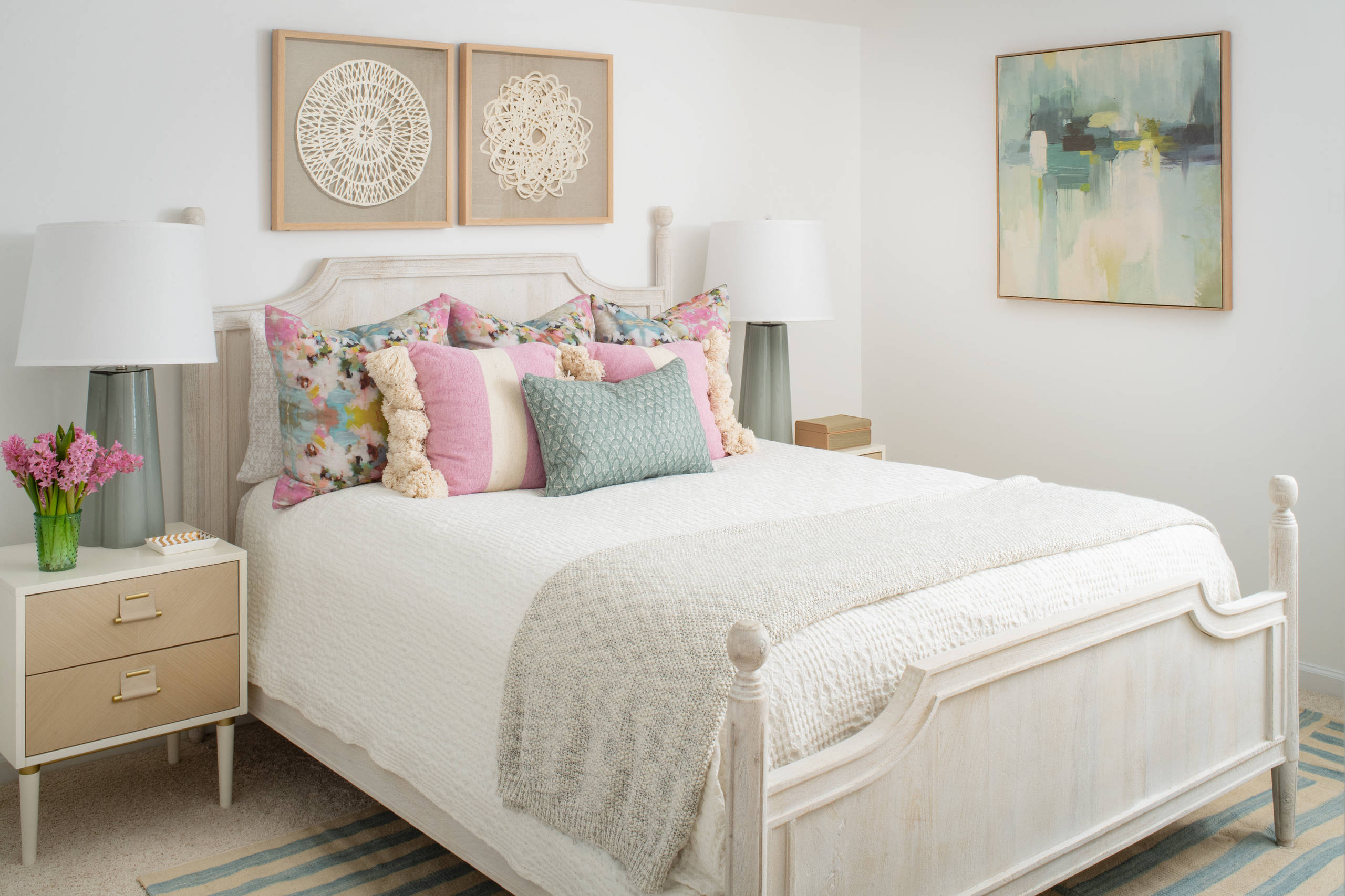 Modern beach style bedroom with pink pillows and coastal accents