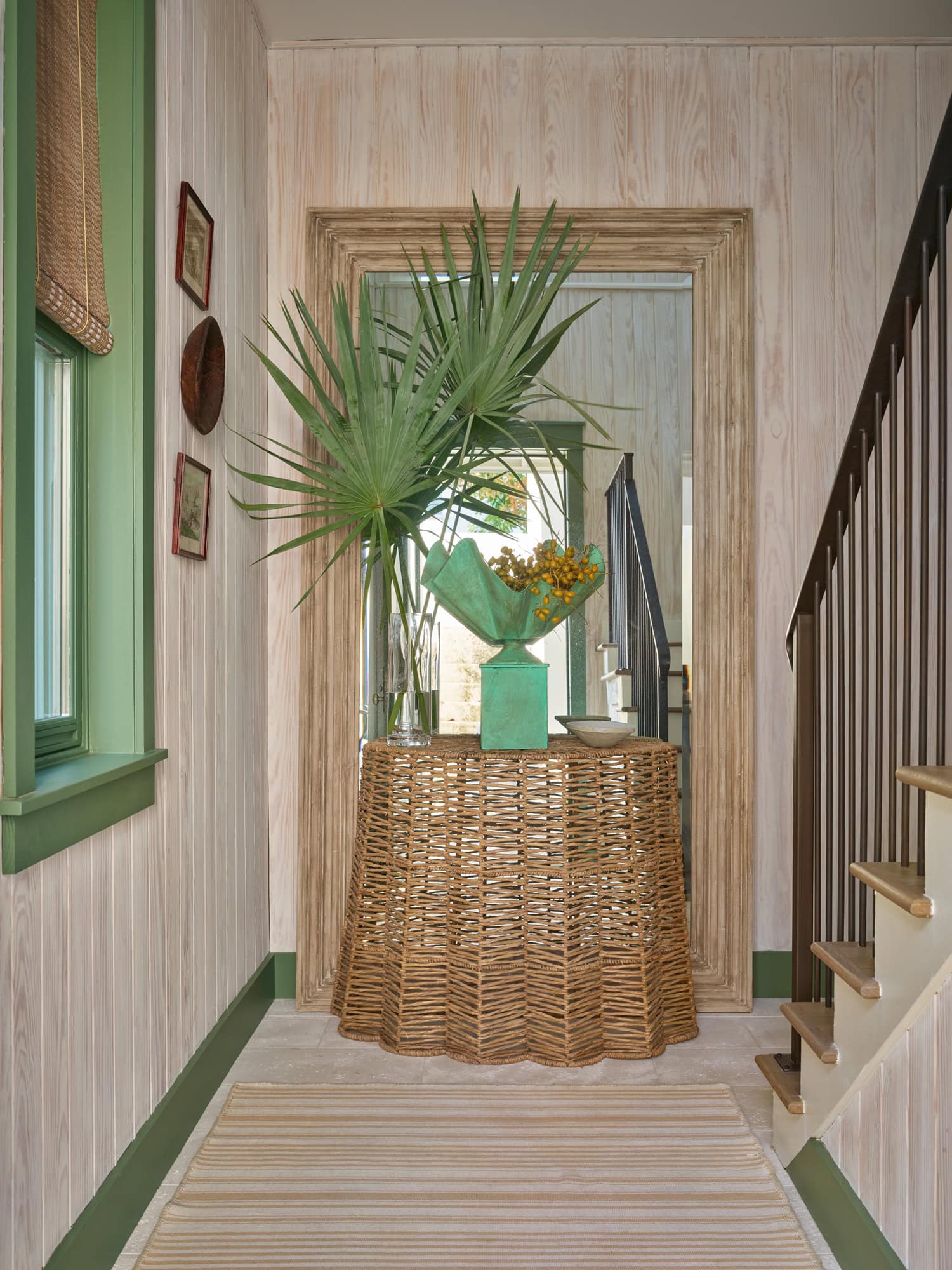Designer Spotlight about Ashley Gilbreath Interiors Design project featuring a entryway with pops of green and rustic textures in a tropical style mixed with traditional and modern home accents.