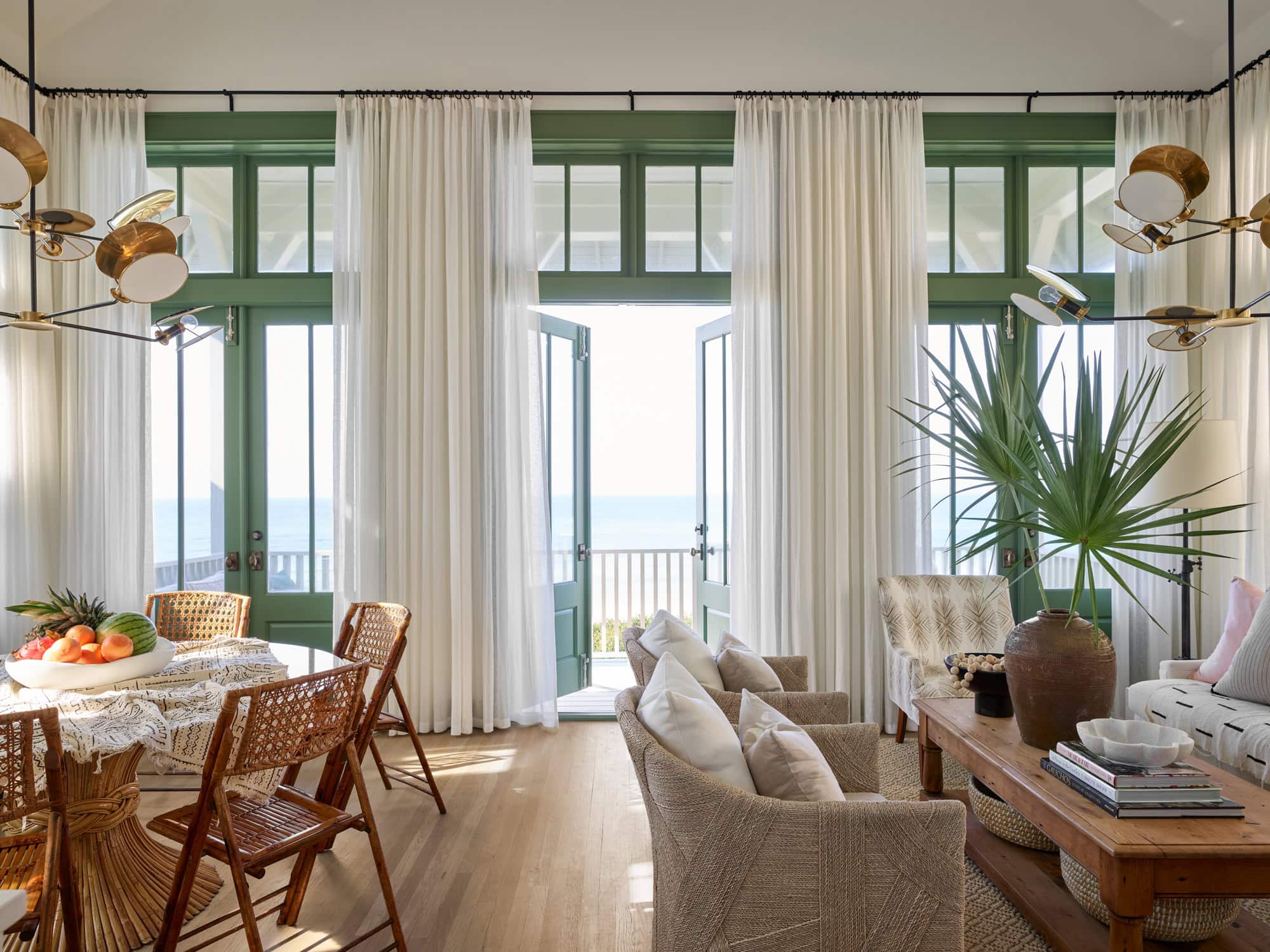 Designer Spotlight about Ashley Gilbreath Interiors Design project featuring a open concept living room with pops of green and rustic textures in a tropical style mixed with traditional and modern home accents.