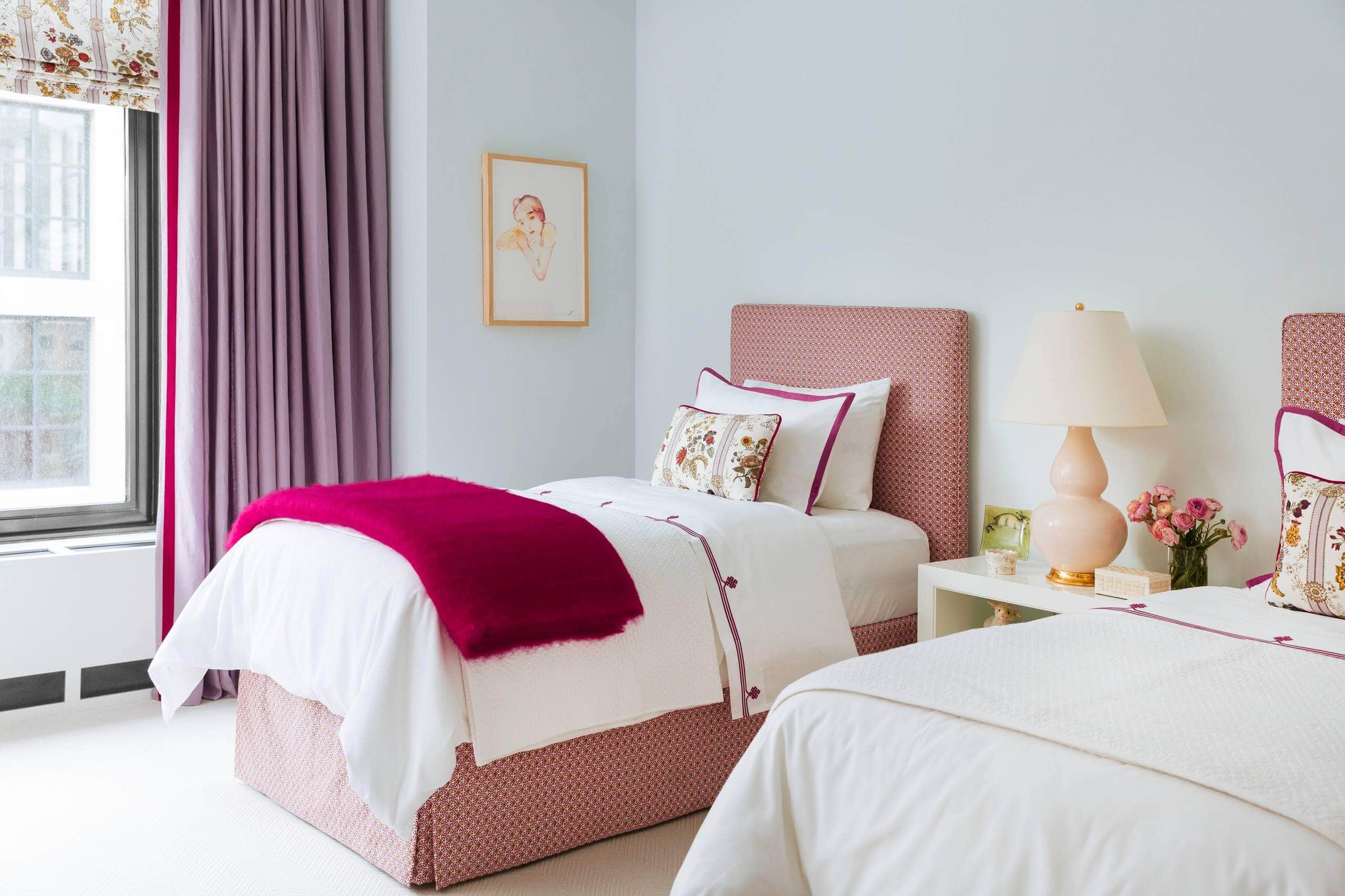 Mid-sized transitional kids' room featuring twin beds, with light blue walls and hot pink decor accents.Transitional aesthetic with vibrant pops of color.