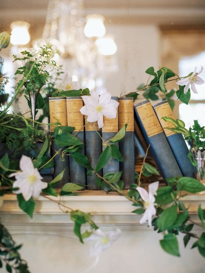 Fall mantel ideas for living room decor featuring a mantel with books and greenery