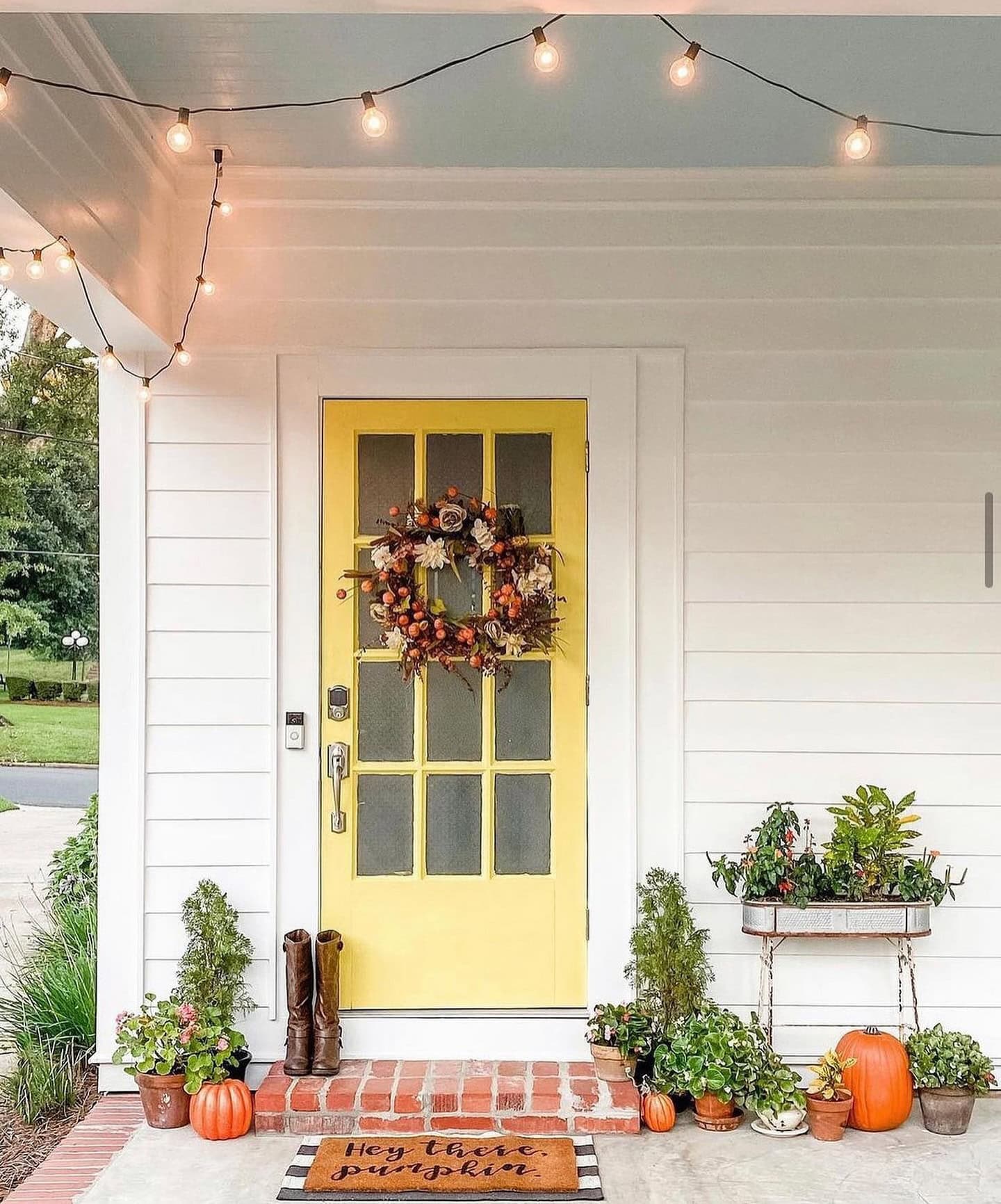 Example of fall porch decorations featuring a yellow front door
