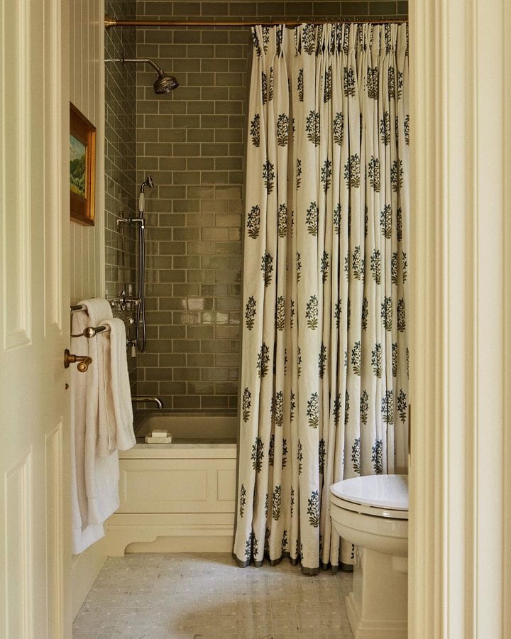 Fall bathroom decor idea featuring olive green tiles and pattern curtains