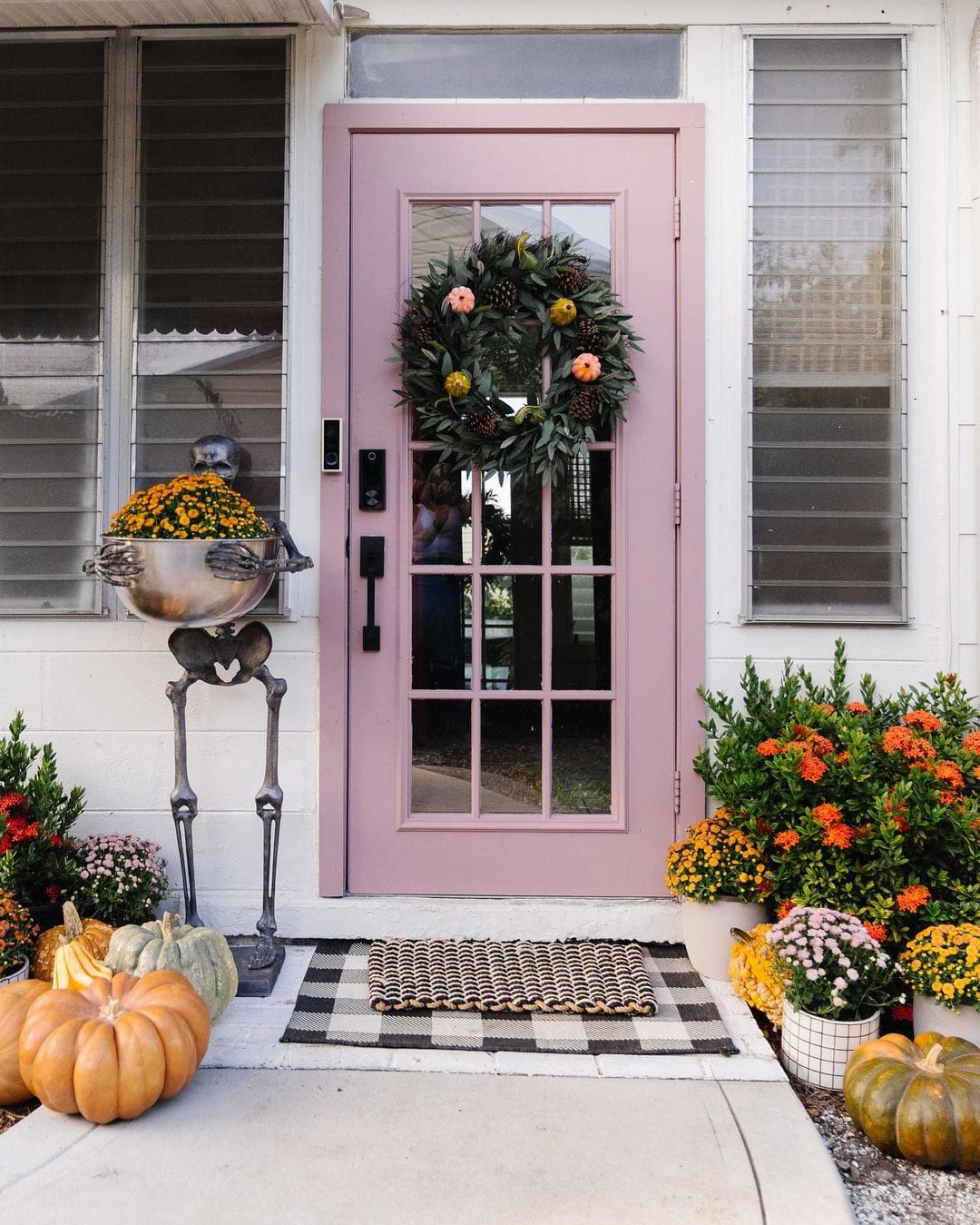 Example of fall porch decorations featuring a soft pink door
