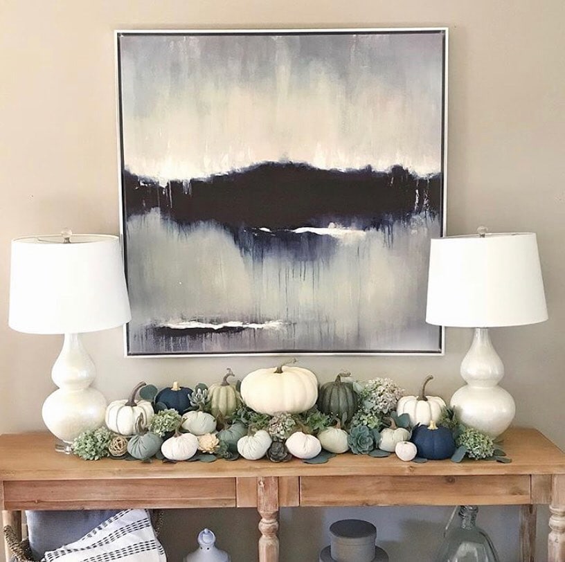 Fall decor idea featuring coastal styled living room with blue pumpkins on mantel