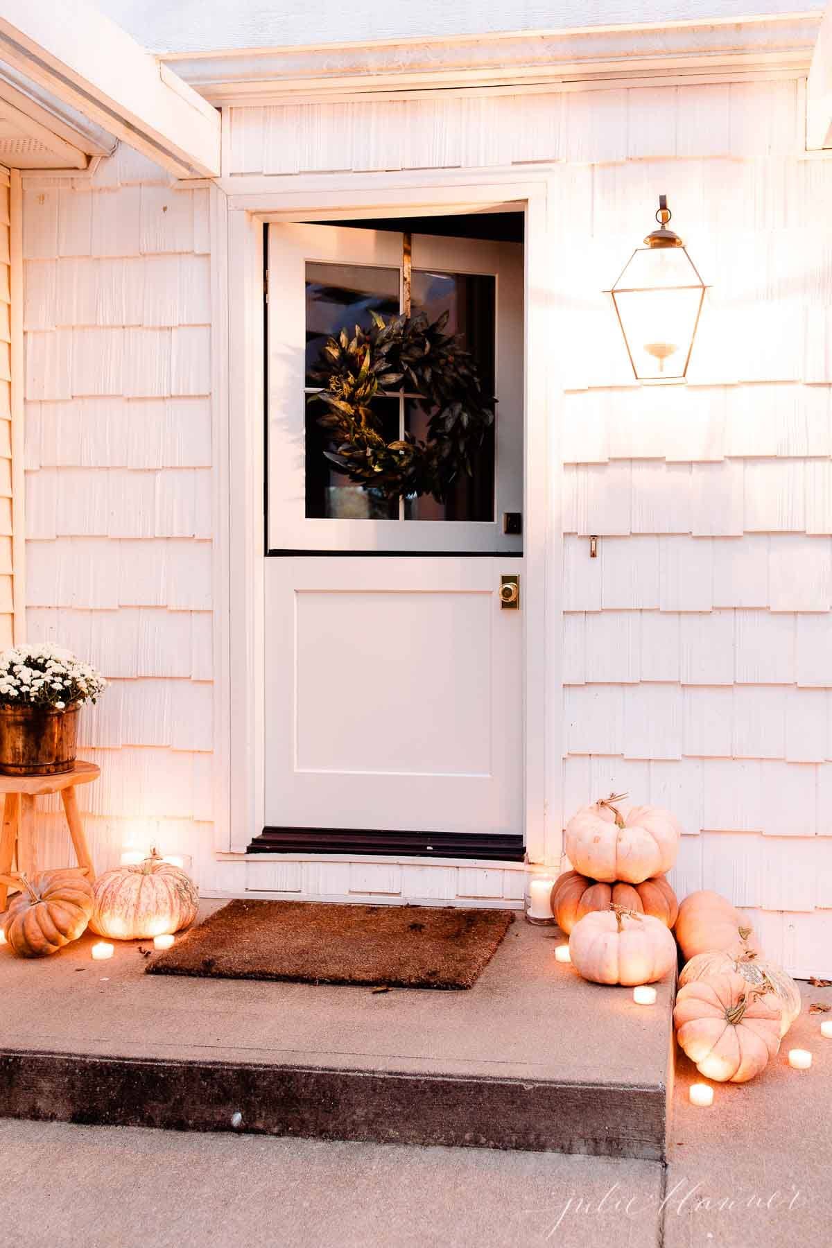Example of fall porch decorations featuring a front porch with cozy flickering pumpkins