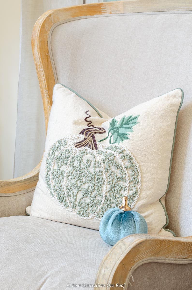 Fall decor idea featuring armchair with velvet blue pumpkins and pillow