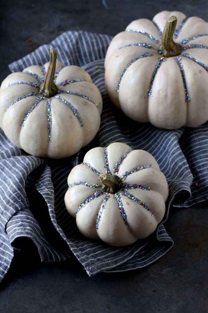 Creative no carve pumpkin decorating idea featuring white pumpkin with silver glitter lines