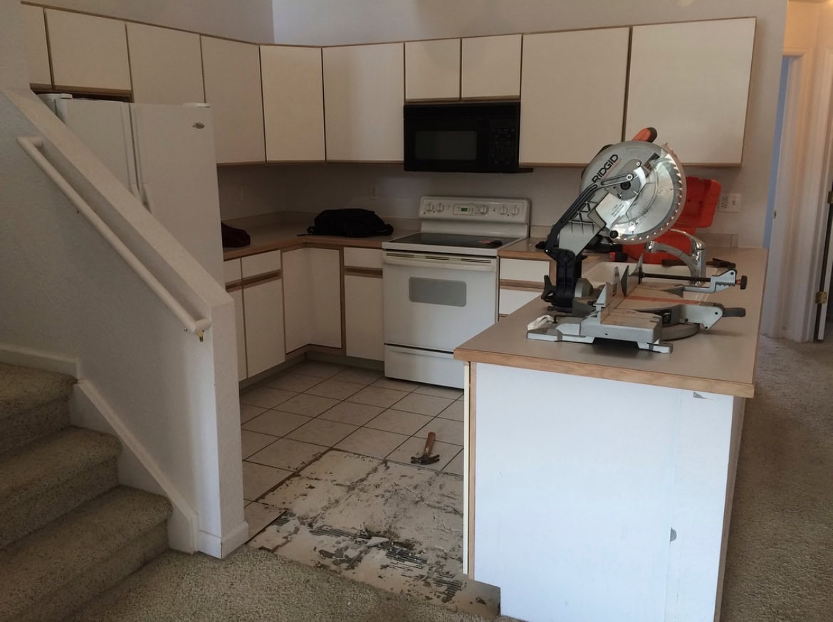 Outdated kitchen with original cabinets, carpet flooring, and no backsplash in a Colorado condo before the DIY renovation.