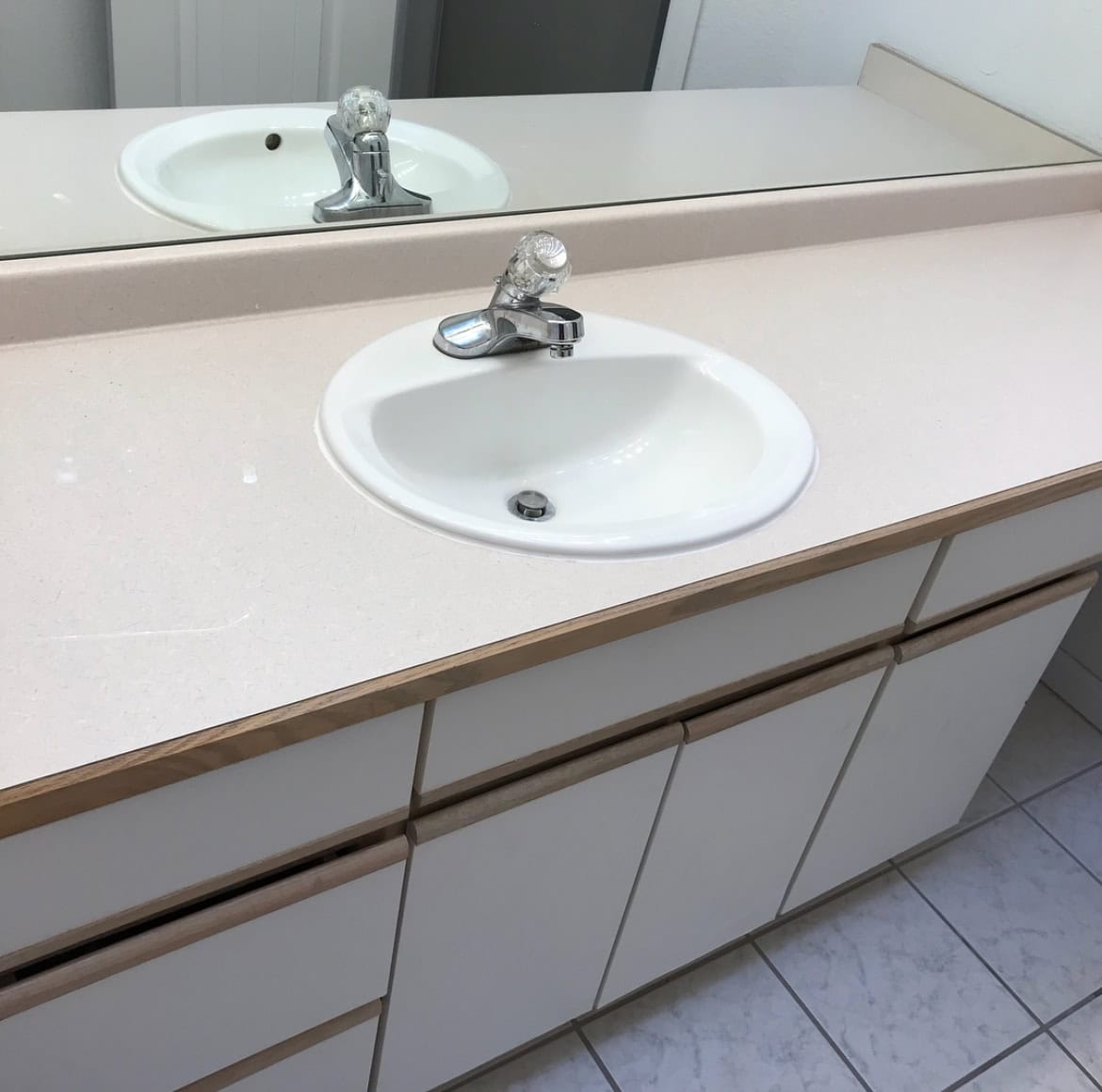 Original bathroom with carpet flooring, outdated sink, and fixtures in a Colorado condo before the DIY renovation.