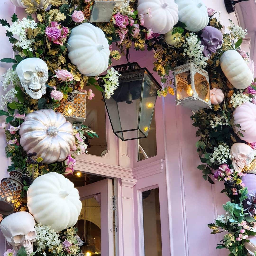 Pink Halloween decorations example featuring an entryway arch made of floral arrangements