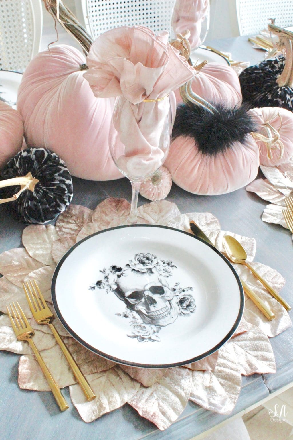Pink Halloween decorations example featuring an table setting with pale pink and black decor