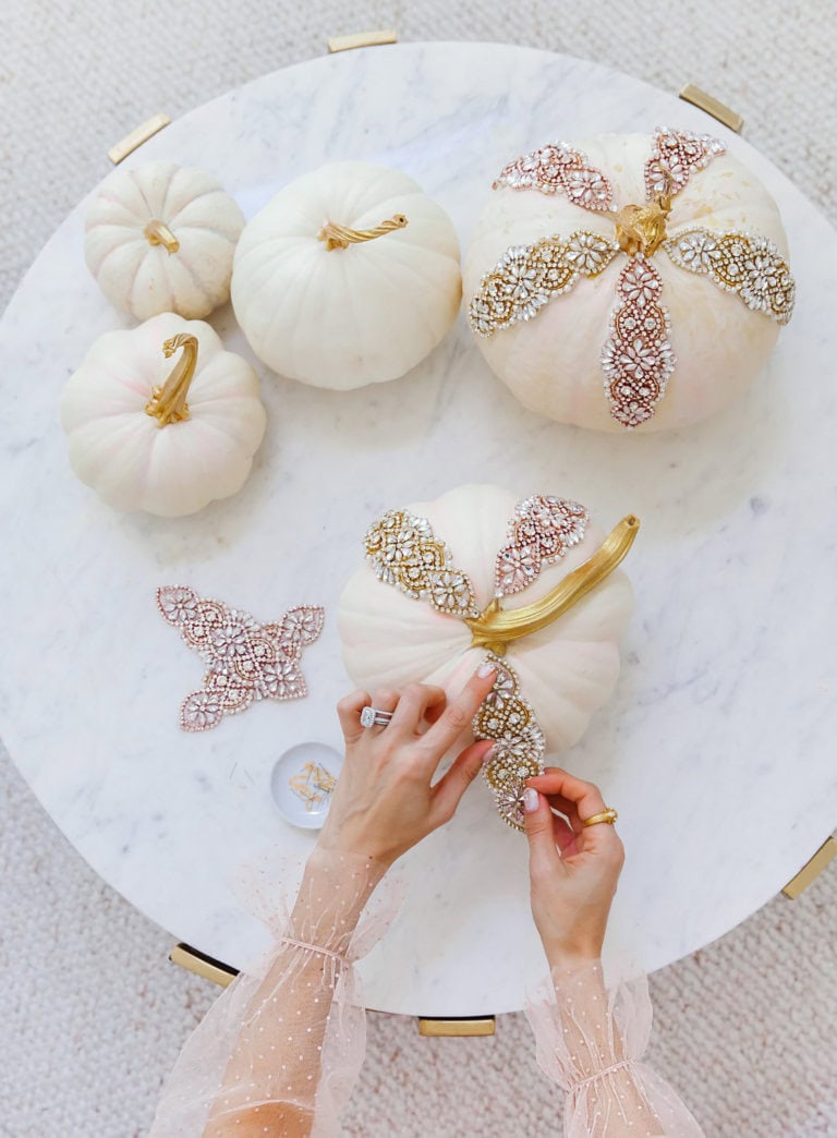 Creative no carve pumpkin decorating idea featuring white pumpkins with lace and glitter apliques