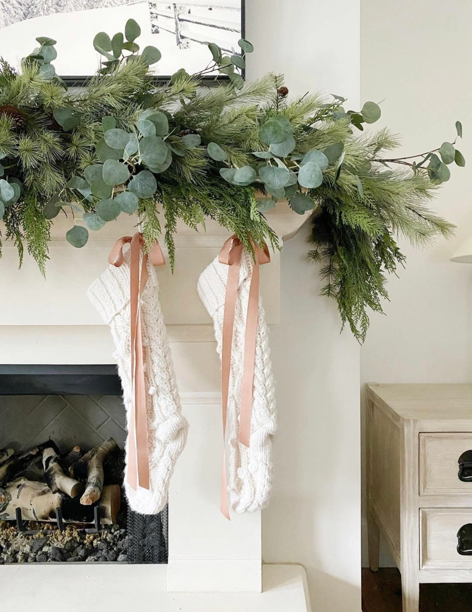 Example of cozy Christmas decor featuring living room decorated with garland in modern heritage style.