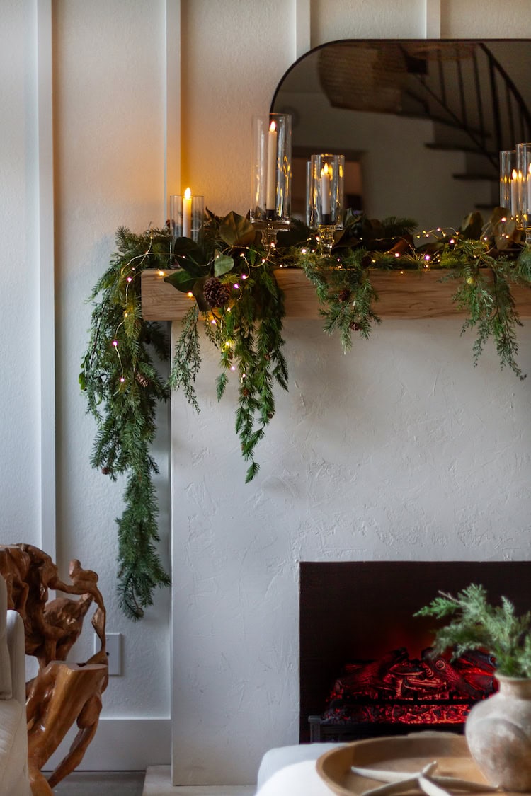 Example of cozy Christmas decor featuring living room decorated with garland in traditional style.