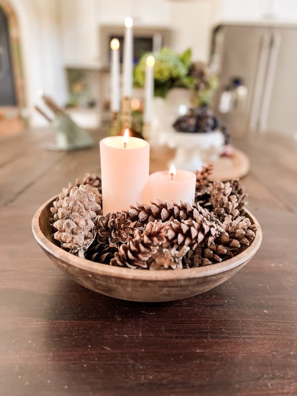 Friendsgiving Aesthetic inspiration idea featuring a bowl with pinecones and candles