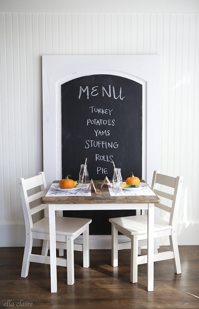Thanksgiving kids table fun decor idea featuring chalkboard behind table set