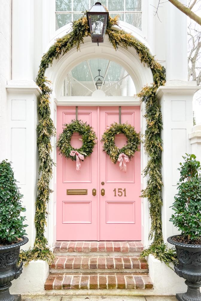 Pink Christmas Decorations inspiration, showcasing a pink front door and paired garlands wit h matching pink bows