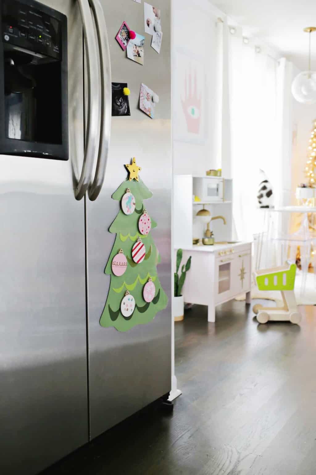 Kid-friendly Christmas decor ideas example featuring a DIY paper tree attached to fridge door