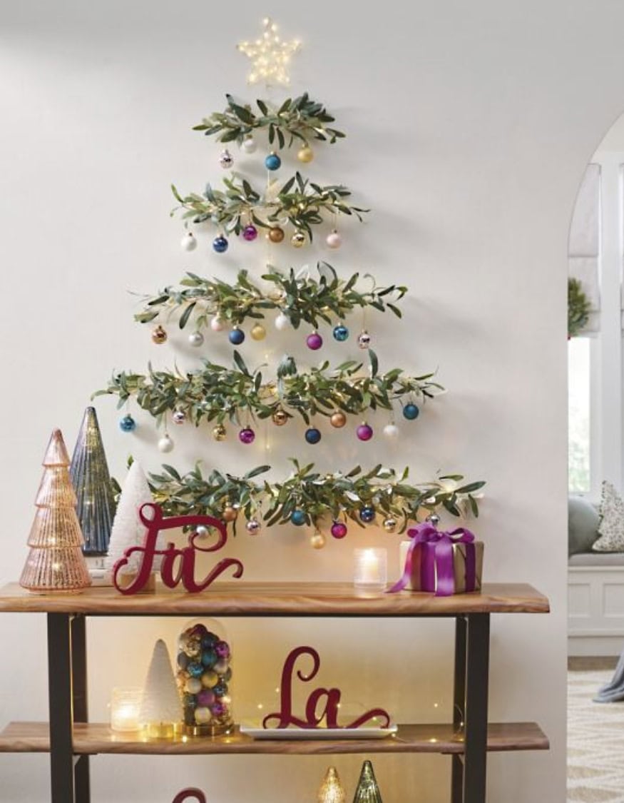 Kid-friendly Christmas decor ideas example featuring half christmas tree above rustic bench